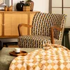 A chair and ottoman are set up in a room with a cabinet and blanket. Náhled obrázku produktu
