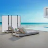 A modern outdoor living space with a view of the ocean, featuring lounge chairs and a privacy screen. Produktbild-Vorschau