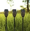 Three solar garden lights shaped like torches are placed in tall green grass with trees in the background. Produktbild-Vorschau