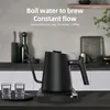 A black electric gooseneck kettle is on a black base with two small glasses next to it on a tray. The background is a kitchen counter and wall. Náhled obrázku produktu