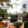 A Steinborg minibackofen is shown on a table on a balcony with a city view in the background. Produktbild-Vorschau