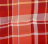 A close-up of a red, orange, and white plaid fabric. Produktbild-Vorschau