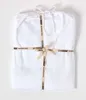 A white duvet or sheet set is neatly folded and tied with a ribbon. Produktbild-Vorschau
