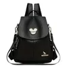 A black leather backpack with a Mickey Mouse-like emblem on the front flap and a kangaroo logo on the lower front. Podgląd zdjęcia produktu