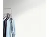 A clothing rack with several garments hanging on it, set against a plain background with soft lighting. Náhľad obrázku produktu
