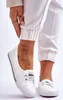 A woman's feet wearing white sneakers and white pants. Voir les images du produit