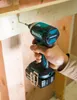 A hand holding a Makita impact driver, screwing into a wooden beam. Produktbild-Vorschau