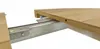 A close-up view of a wooden table extension mechanism, showing the sliding rails and the underside of the table top. Náhled obrázku produktu