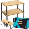 A two-tiered bamboo shelf unit with dark gray metal legs, shown with a smaller version of the shelf unit and its packaging. Produktbild-Vorschau