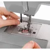 A close-up shot of a person's hands threading a sewing machine. Anteprima dell’immagine prodotto