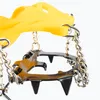 A close-up view of yellow crampons with metal spikes and chains. Produktbild-Vorschau