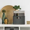 A decorative shelf display with various items including baskets, books, a plant, a Buddha head, and a decorative plate. Voir les images du produit