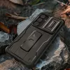 A black phone case with a kickstand is placed on rocks and fallen leaves. Náhľad obrázku produktu