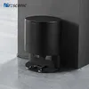 A black automatic dust removal station for a robot vacuum cleaner is shown in a corner, leaning against a wall. Voir les images du produit