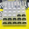 A clear, top-down view of a plastic storage box filled with spools of thread. The box is open, revealing rows of white and black thread spools. Produktbild-Vorschau