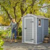 A woman with a bicycle stands next to a garden shed in an outdoor setting with trees and foliage. Náhľad obrázku produktu