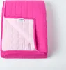 A folded pink quilted blanket is shown against a white background. Produktbild-Vorschau