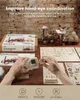 A wooden model steam engine kit is being assembled on a table, with packaging and instructions visible. Produktbild-Vorschau