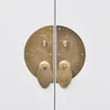 A close-up view of two ornate brass handles on a white cabinet. Anteprima dell’immagine prodotto