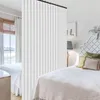 A bedroom scene with two beds separated by a curtain. Voir les images du produit