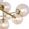 A close-up view of a modern chandelier with multiple glass globes and gold-colored metal accents. Náhľad obrázku produktu