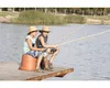 Two boys fishing on a dock with a lake in the background. Produktbild-Vorschau