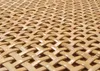 A close-up view of a woven rattan surface, showing the intricate pattern of the material. Produktbild-Vorschau