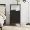 A black nightstand next to a bed, with a lamp in the background. Podgląd zdjęcia produktu
