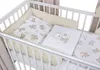 A baby crib with bedding featuring a teddy bear pattern. Produktbild-Vorschau