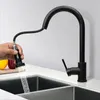 A black kitchen faucet with a pull-down sprayer is shown in use over a sink. Náhled obrázku produktu
