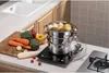 A multi-tiered steamer set is shown on a countertop with fresh vegetables and eggs, suggesting a healthy meal preparation scene. Voir les images du produit