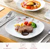 A table setting with plates of food, cutlery, and placemats. Produktbild-Vorschau