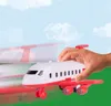 A hand holding a toy airplane with motion blur suggesting movement against a sky and grass background. Produktbild-Vorschau
