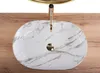 A top-down view of a marble-patterned sink with a gold faucet, placed on a wooden surface. Anteprima dell’immagine prodotto