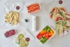 A collection of food items and vacuum sealing accessories laid out on a white surface. Náhľad obrázku produktu