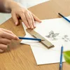 A person's hands are shown drawing on a piece of paper with pencils and a ruler. Podgląd zdjęcia produktu