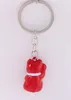A red lucky cat charm on a keychain, photographed against a white background. Produktbild-Vorschau