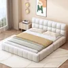 A modern bedroom with a white upholstered bed.