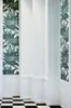 A corner of a room with patterned wallpaper and wainscoting. Náhľad obrázku produktu