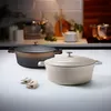 Two cocottes are displayed on a white countertop with a blurred kitchen background. Produktbild-Vorschau