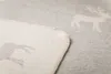 A close-up view of a soft blanket with a deer pattern. Produktbild-Vorschau