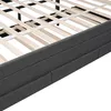 A close-up view of the side of a bed frame, showing the upholstered side panels and the wooden slats of the bed base. Náhled obrázku produktu