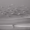 Close-up of water droplets on a gray fabric surface, with a zipper visible in the foreground. Náhled obrázku produktu