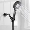 A black hand shower head with water spraying from it, mounted on a black adjustable arm attached to a white tiled wall. Produktbild-Vorschau