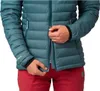 Close-up of a person zipping up a teal puffer jacket, with red pants visible. Anteprima dell’immagine prodotto