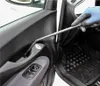 A gloved hand uses a tool to clean the interior of a car door. Produktbild-Vorschau