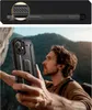 A man is holding a black phone case while hiking on a rocky mountain. Produktbild-Vorschau