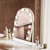 A vanity mirror with lights on a dresser, next to toiletries. Produktbild-Vorschau