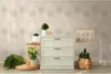 A dresser with plants and decorative items in a room. Produktbild-Vorschau