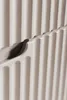 A close-up of a beige cabinet with ribbed fronts, showing a drawer or door detail. Produktbild-Vorschau